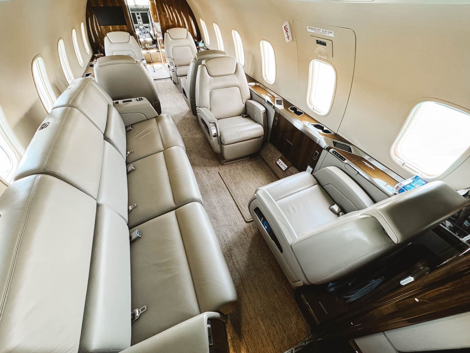 A large business jet cabin after an interior detail — leather divan, club seats, walnut veneer and carpet all finished