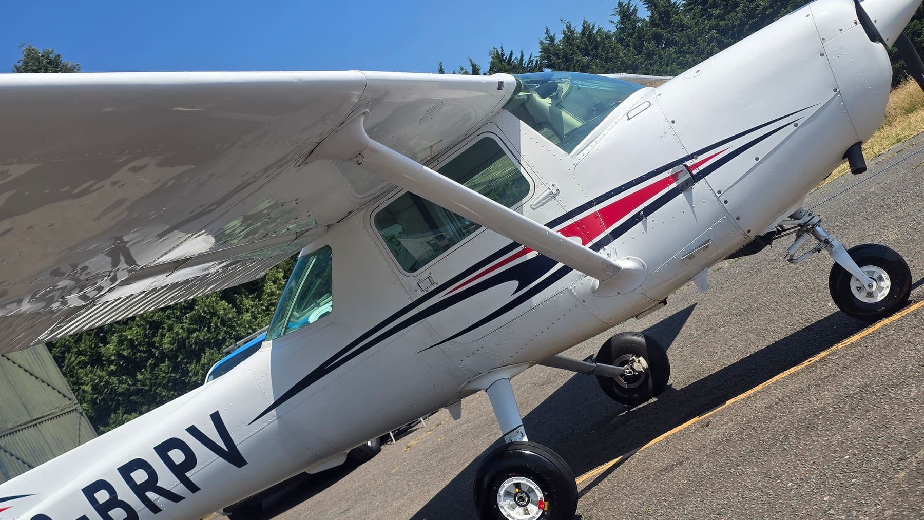 Close angled view of a Cessna 152's polished fuselage and wing strut after detailing