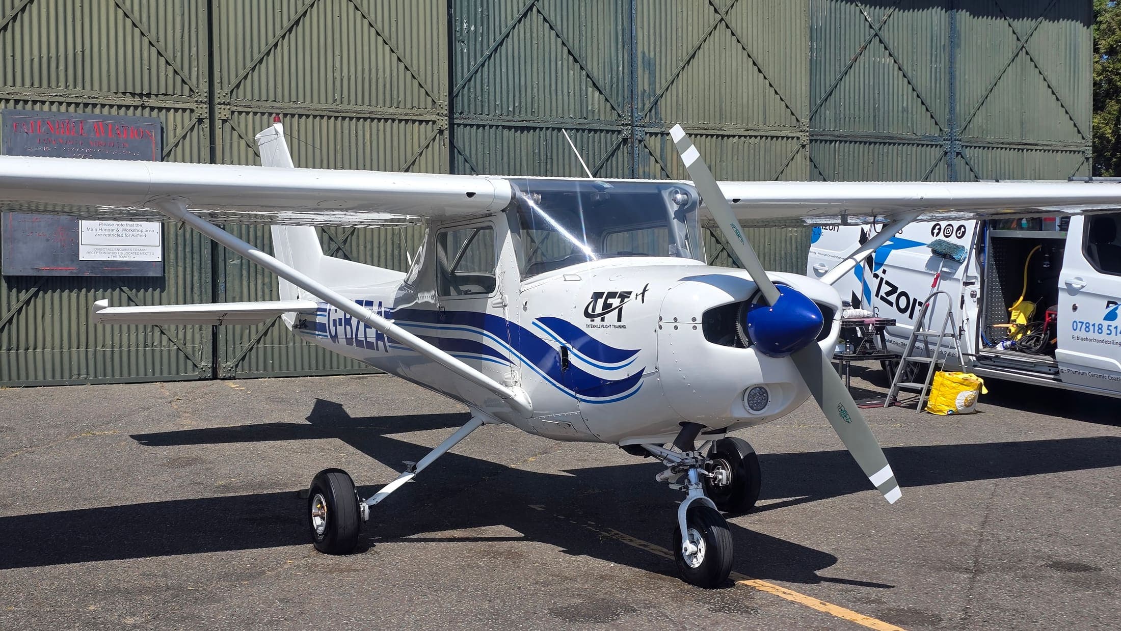 A freshly cleaned Tatenhill Flight Training Cessna 152 outside the hangar with the Blue Horizon service van alongside
