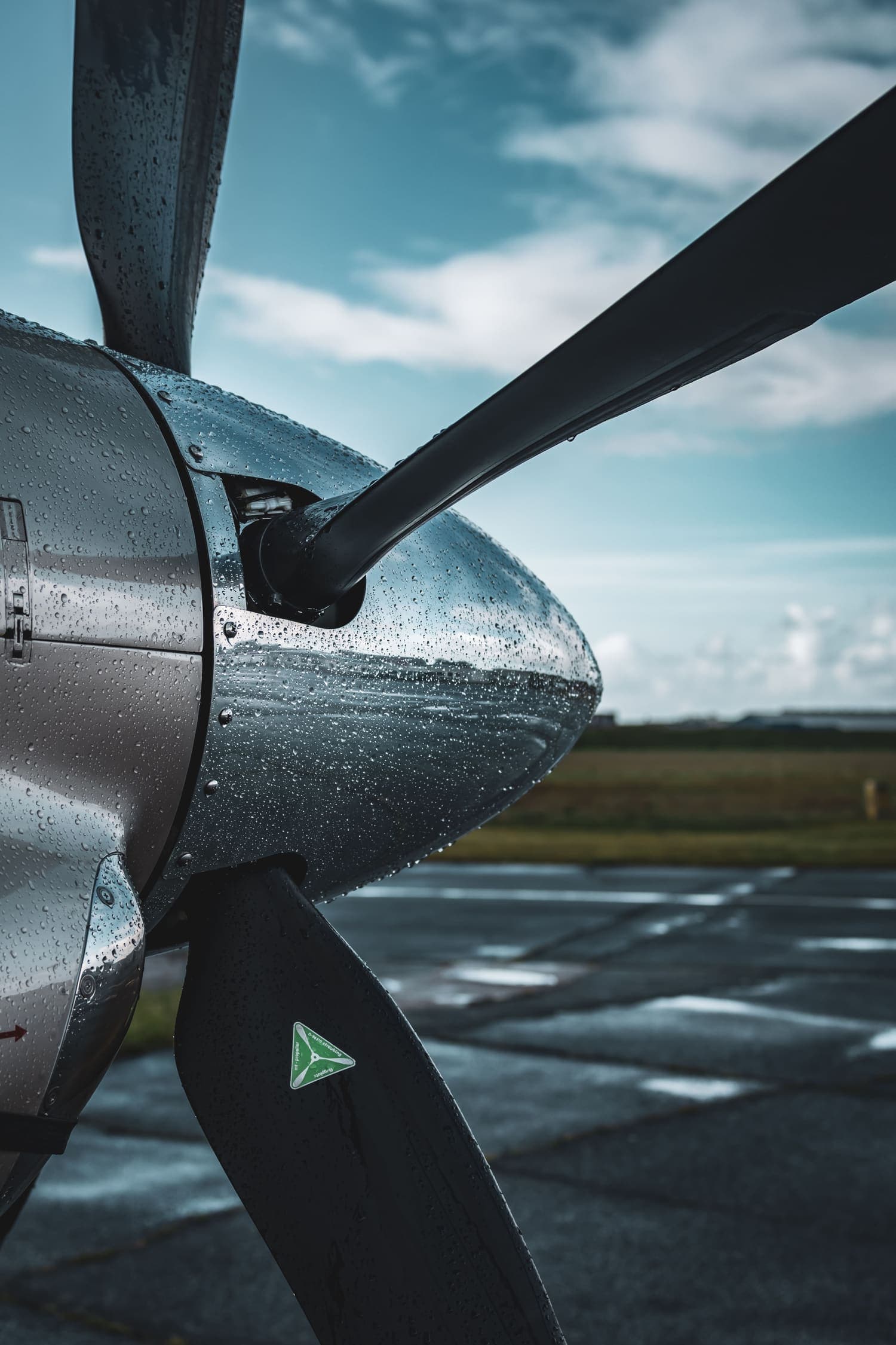 Rainwater beading tightly across a polished propeller spinner protected with a coating after brightwork restoration